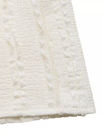 Close-up of a textured white fabric with a subtle pattern on a white background