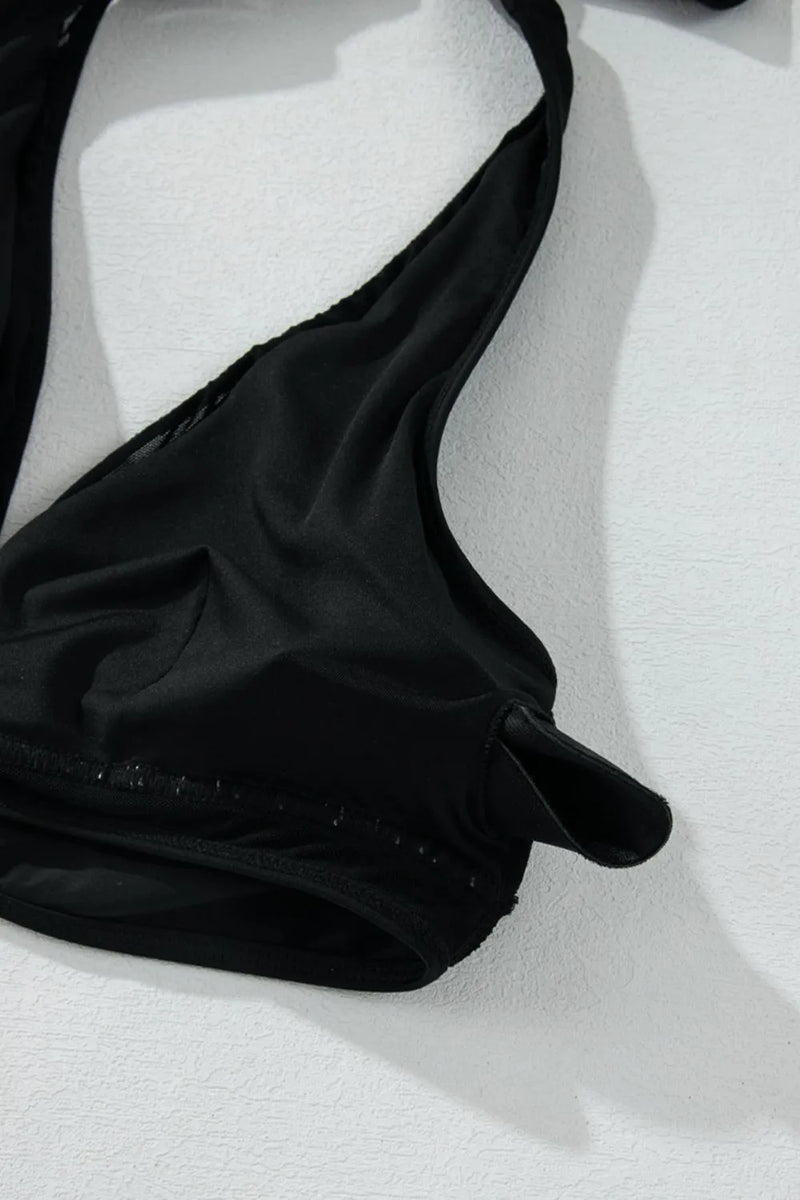 Black bikini top on a white textured surface