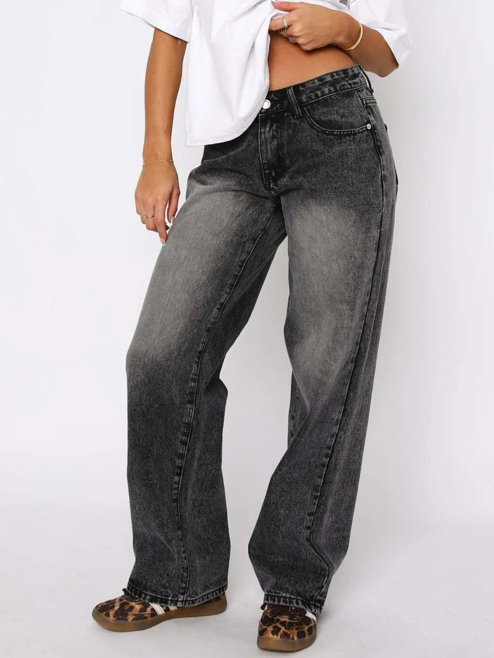 Person wearing black jeans and a white shirt on a white background