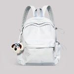 Light blue backpack with a dog-shaped charm on a gray background