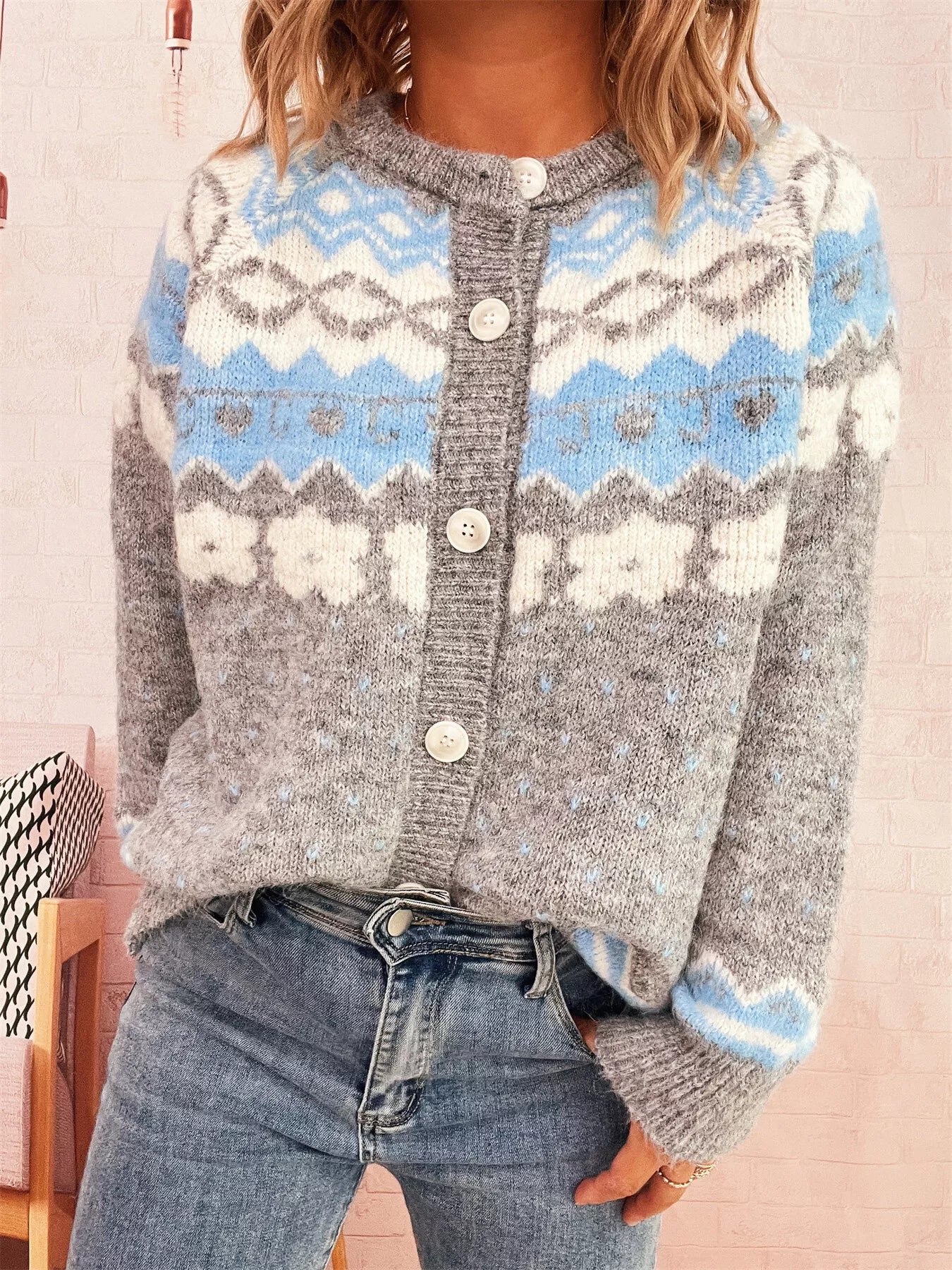 Person wearing a patterned cardigan with blue, white, and gray colors.