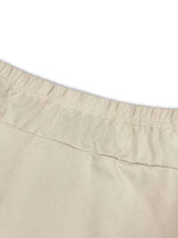 Close-up of beige shorts with a white background
