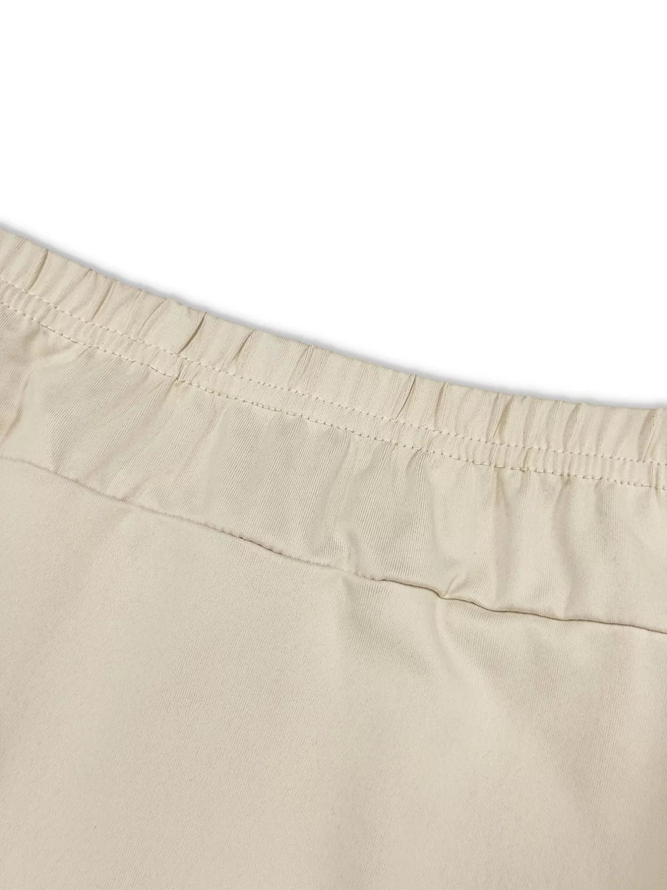 Close-up of beige shorts with a white background