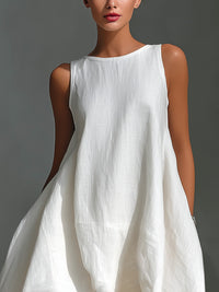 Woman wearing a white sleeveless dress against a gray background