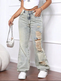 Person wearing ripped light blue jeans with a white background