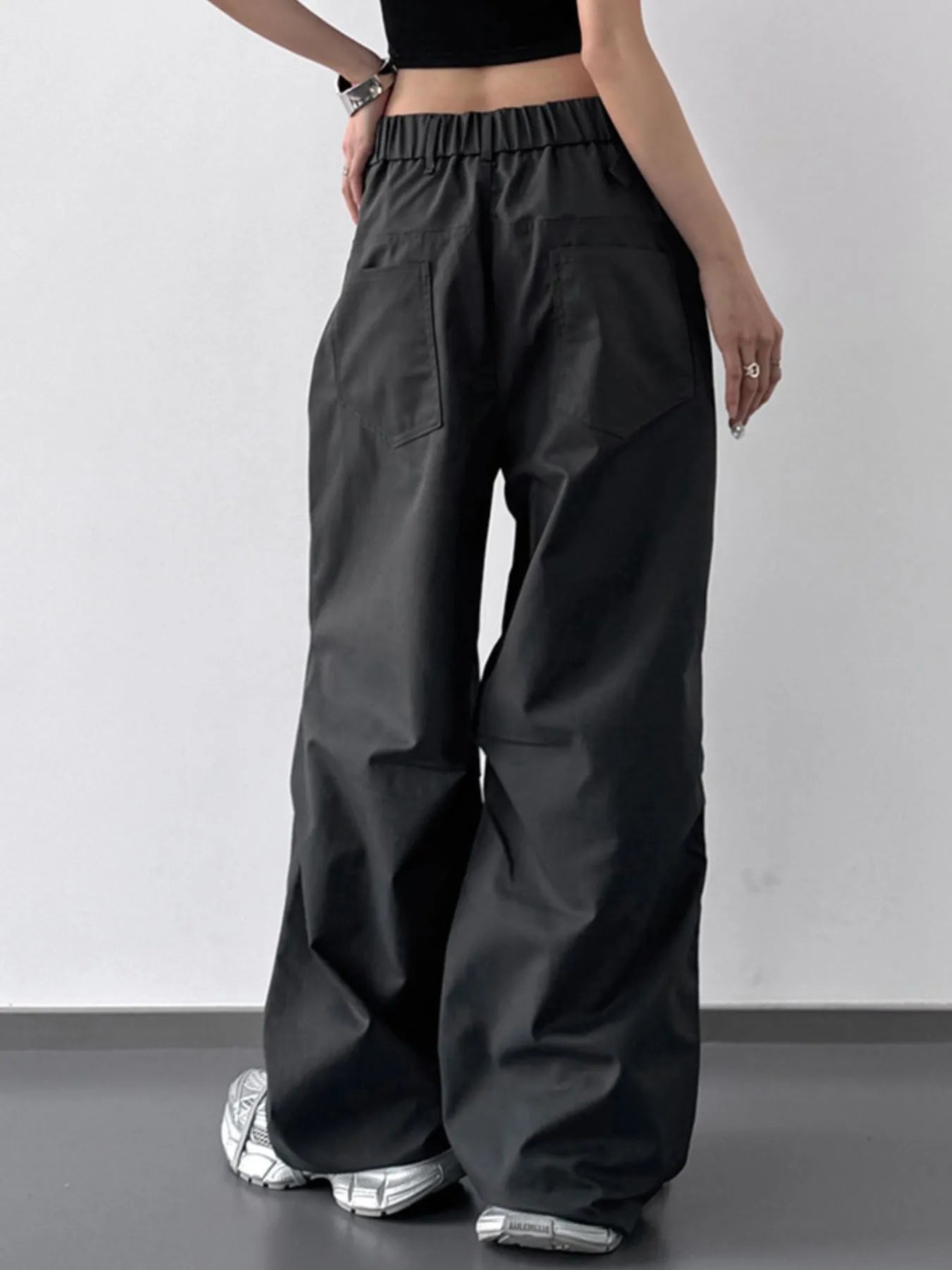 Person wearing black wide-leg pants on a plain background
