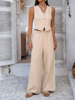 Woman wearing a beige sleeveless top and wide-leg pants in an outdoor setting.