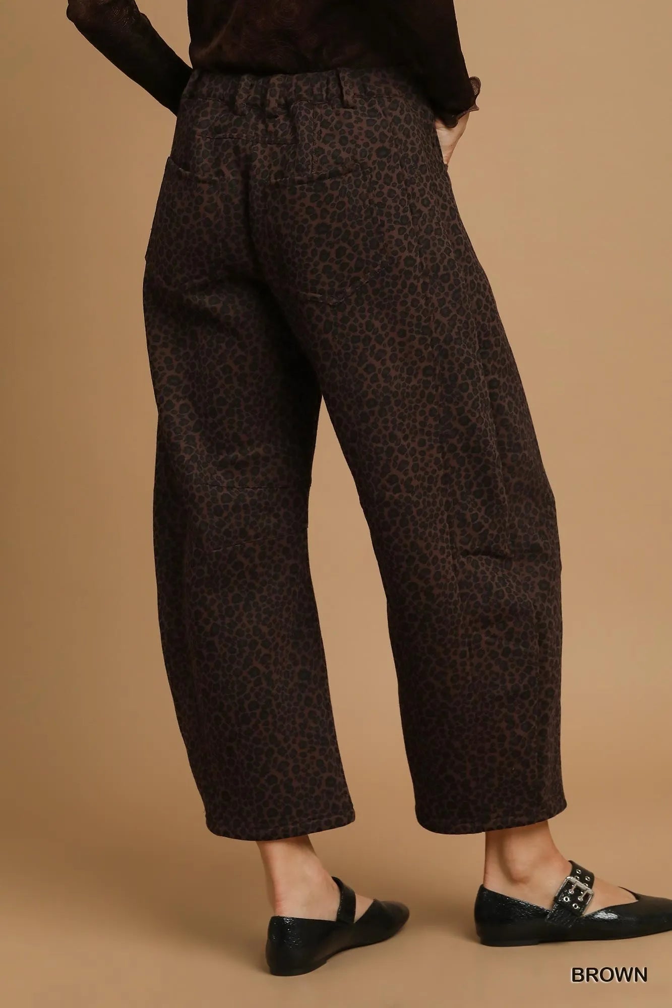 Brown patterned pants worn by a person on a beige background