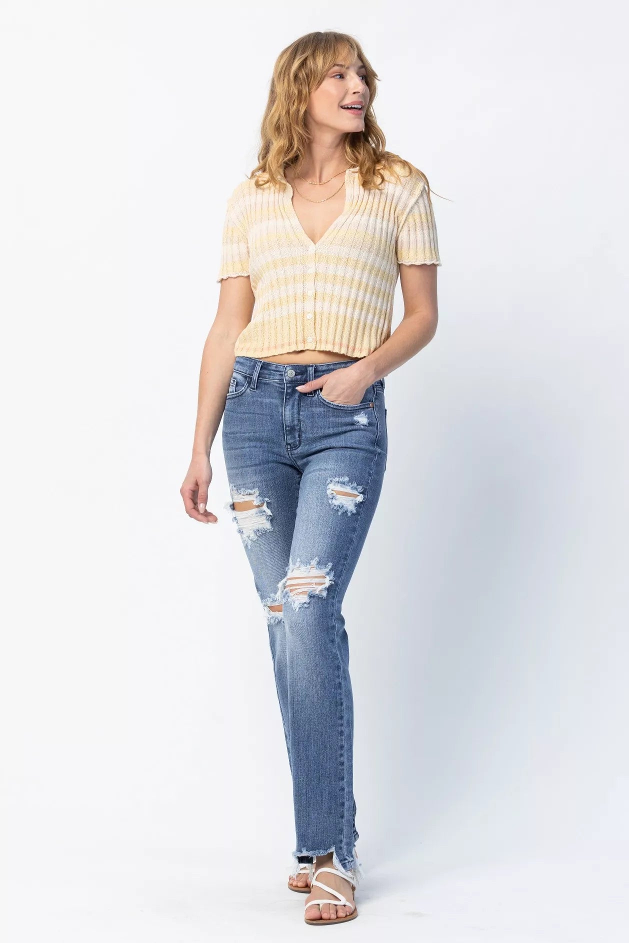 Woman wearing a yellow striped shirt and blue jeans on a white background