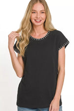 Woman wearing a black t-shirt with white trim on a white background