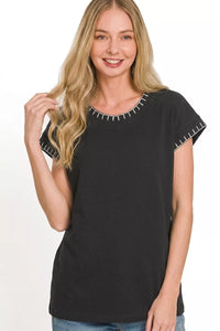 Woman wearing a black t-shirt with white trim on a white background