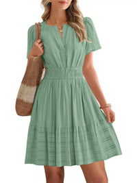 Woman wearing a green dress holding a woven bag on a white background