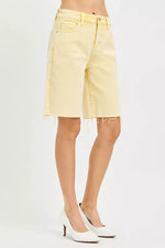 Yellow denim shorts worn by a person on a white background