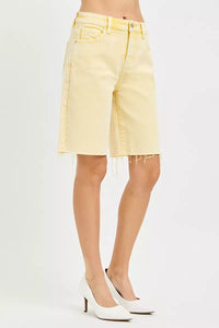 Yellow denim shorts worn by a person on a white background