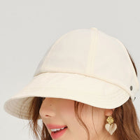Beige bucket hat worn by a person on a plain background