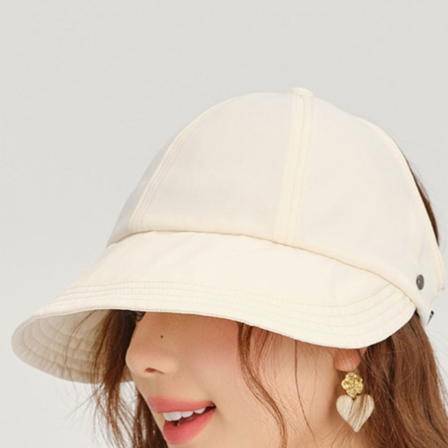 Beige bucket hat worn by a person on a plain background