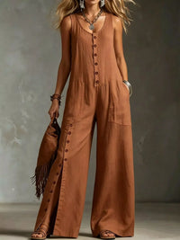 Woman wearing a brown button-up jumpsuit holding a brown bag against a neutral background