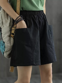 Person wearing a green top and black skirt holding a backpack against a gray background