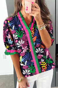 Person wearing a colorful floral kimono-style top taking a mirror selfie.