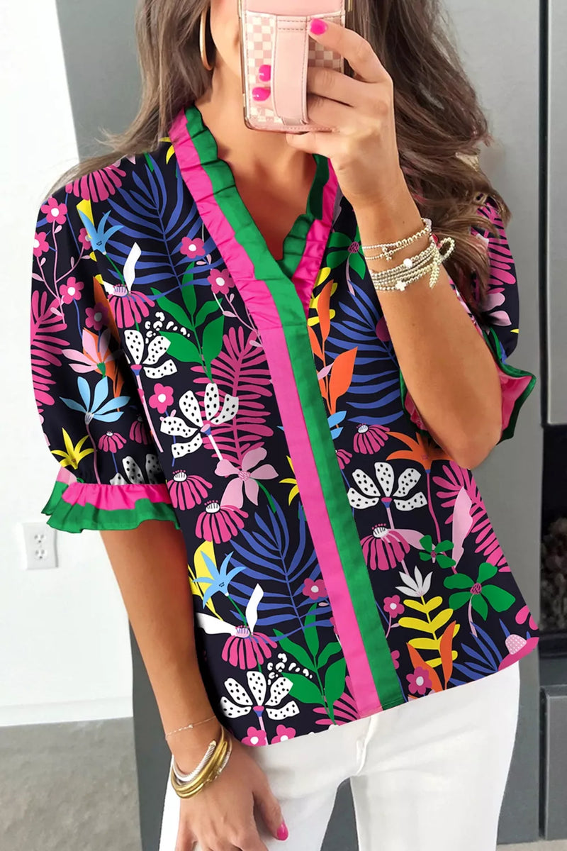 Person wearing a colorful floral kimono-style top taking a mirror selfie.