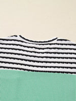 Close-up of a striped garment with black and white horizontal stripes on a beige background