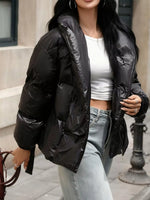 Person wearing a black puffer jacket with a blurred background