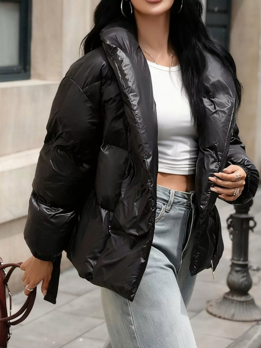 Person wearing a black puffer jacket with a blurred background