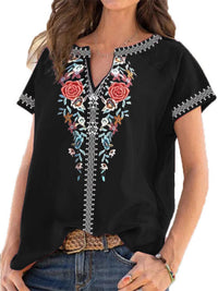 Black blouse with floral embroidery on a white background