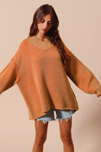 Woman wearing a large orange knitted sweater against a beige background
