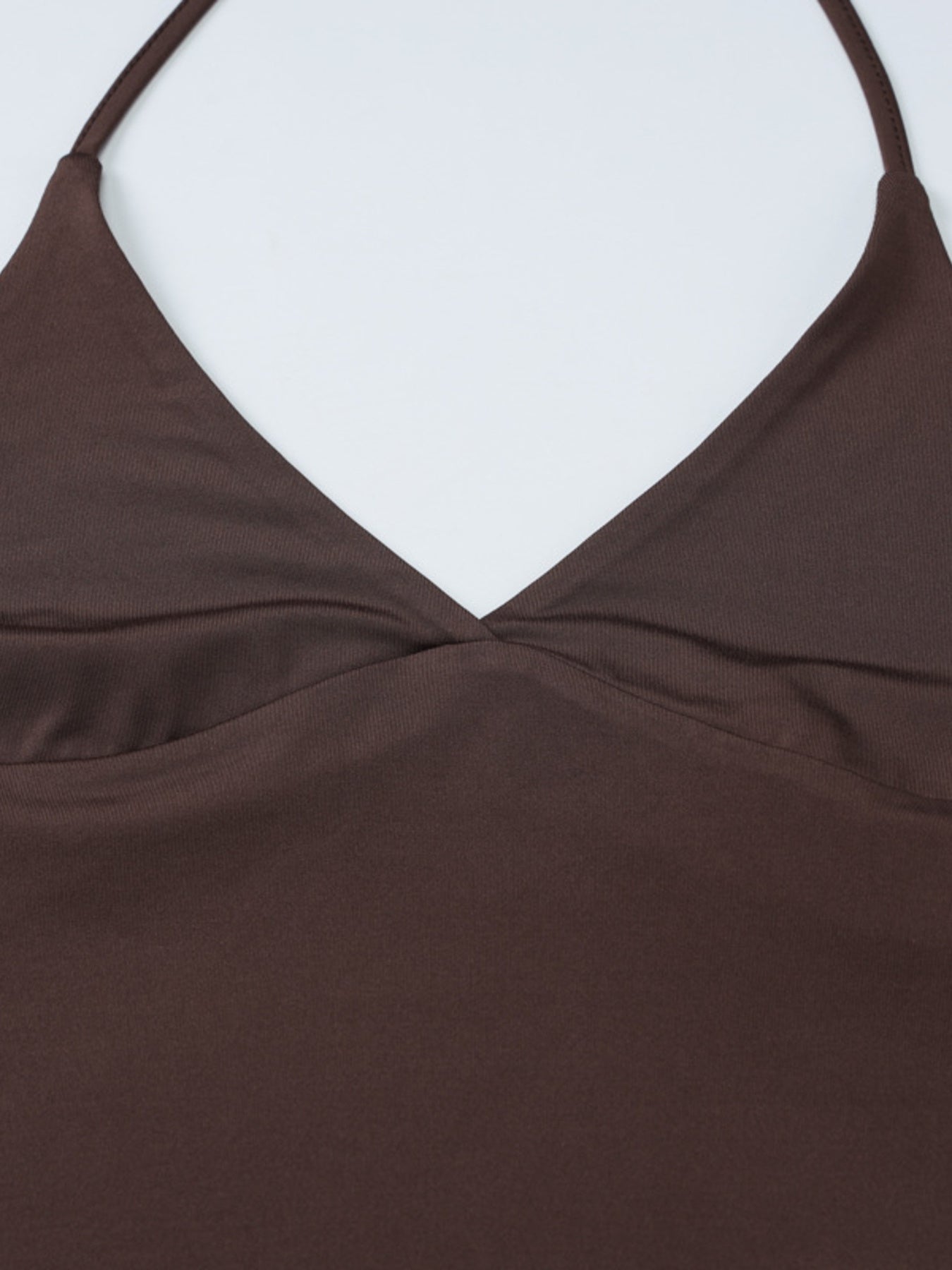 Close-up of a brown top with thin straps on a white background