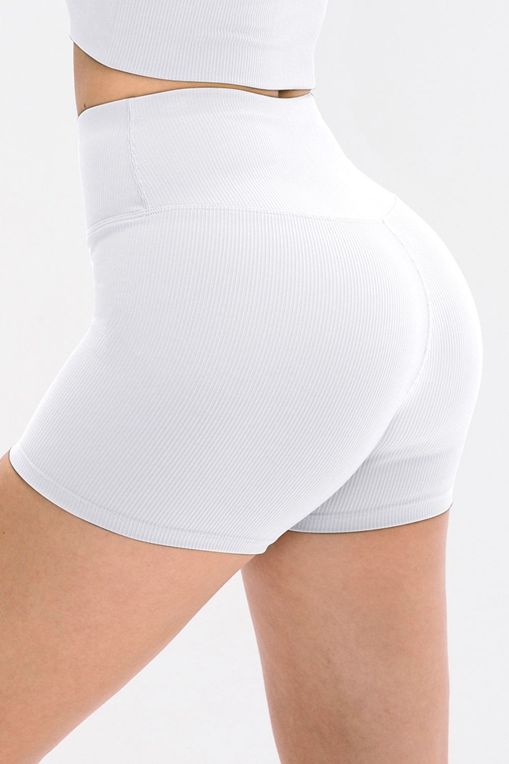 White athletic shorts worn by a person on a light gray background