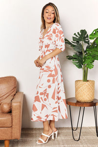 Woman in a floral dress standing in a living room with a plant and couch.
