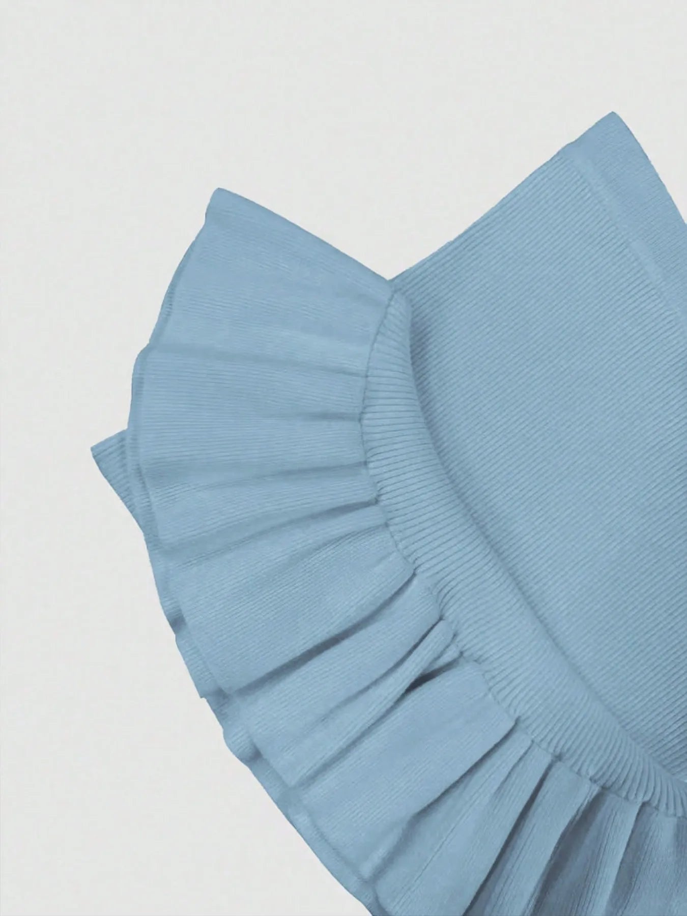 Light blue fitted sheet with ruffled edge on a white background