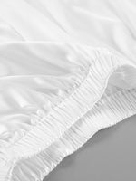 Close-up of a white fitted sheet on a bed