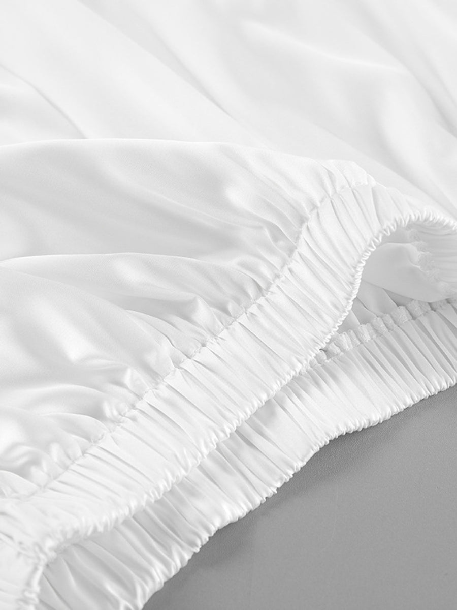 Close-up of a white fitted sheet on a bed