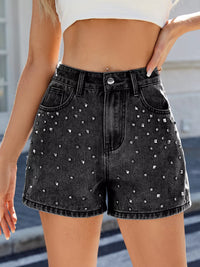 Black denim shorts with rhinestone embellishments worn by a person.