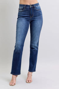 Blue jeans worn by a person on a plain background