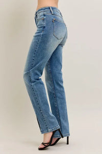 Blue jeans worn by a person on a beige background
