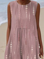 Person wearing a sleeveless, patterned dress on a beach.
