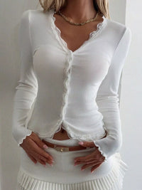 White long-sleeve top with lace details on a plain background