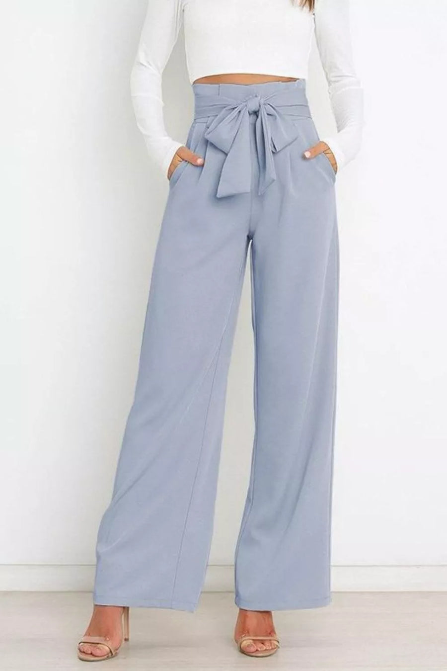 Light blue wide-leg pants with a tie waist worn by a person on a white background