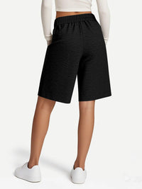 Person wearing black shorts on a white background