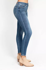 Blue jeans worn by a person on a white background