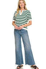 Woman wearing a green and white striped shirt and blue jeans on a white background