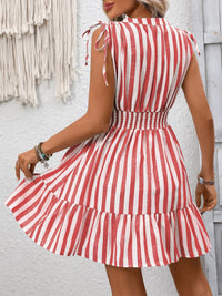 Red and white striped dress worn by a person against a light gray wall.