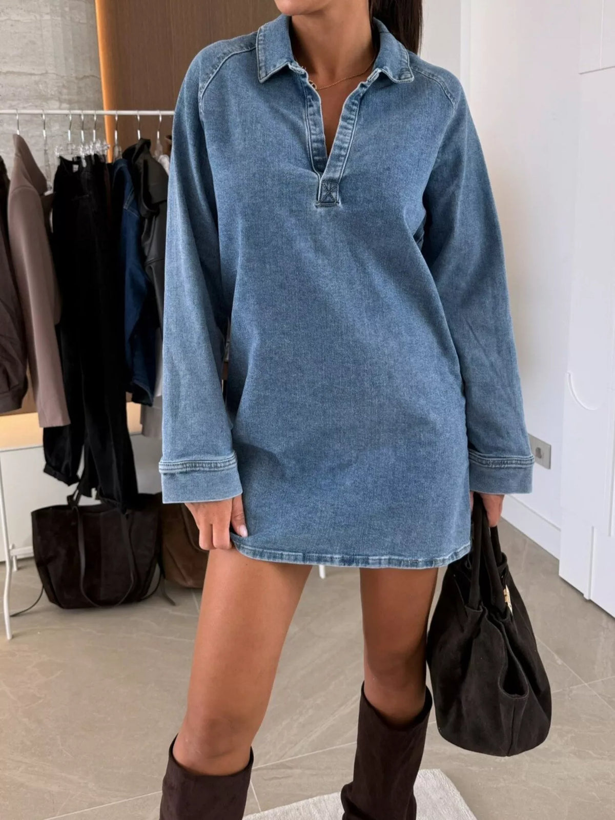 Person wearing a blue denim dress in an indoor setting