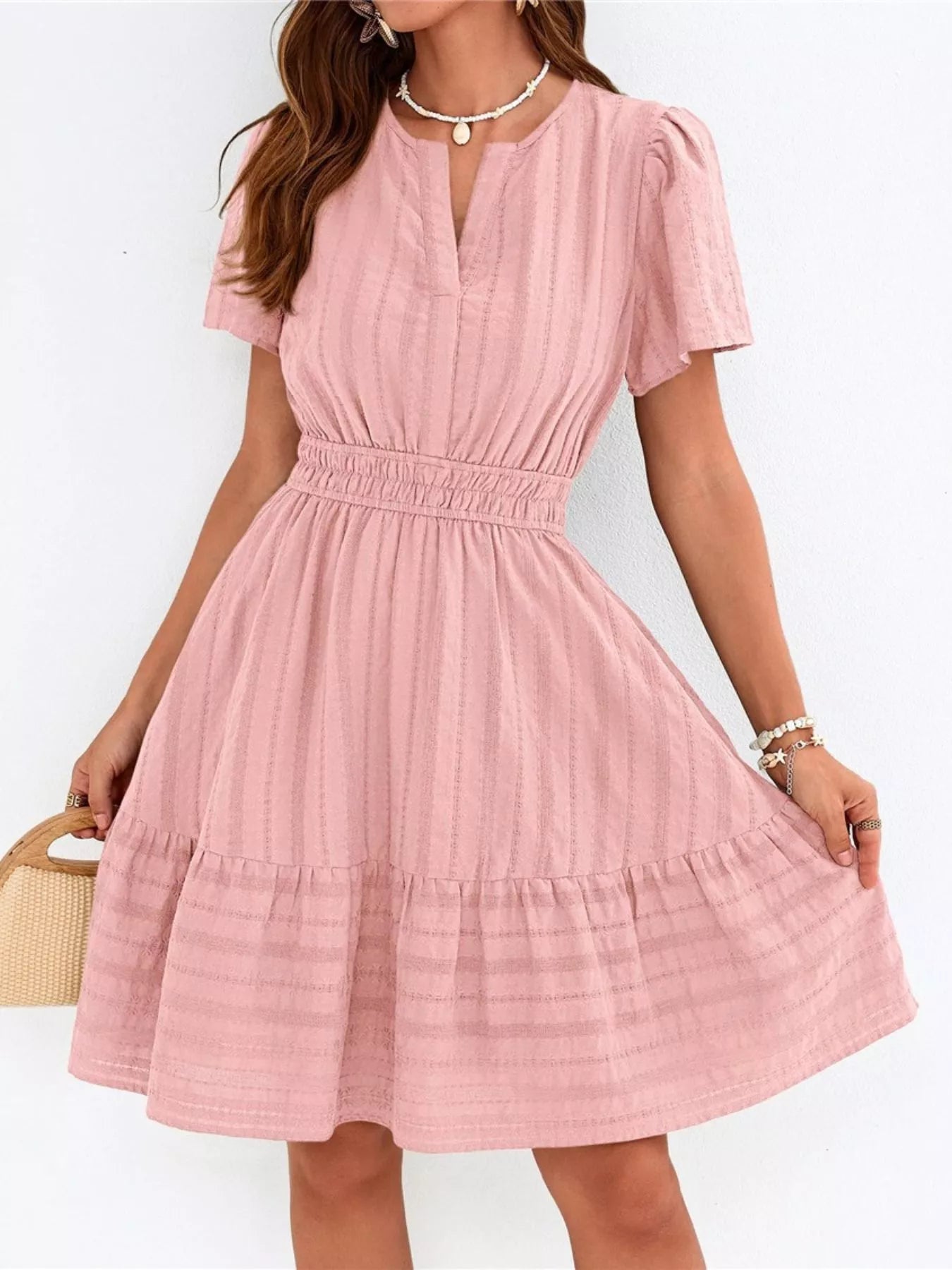 Pink dress worn by a person on a white background