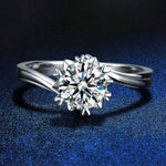 Silver ring with a large diamond on a dark blue textured background