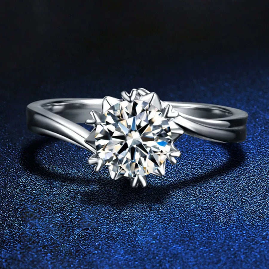 Silver ring with a large diamond on a dark blue textured background