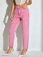 Person wearing pink jeans and white shoes on a plain background